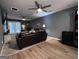 Cozy living room features a comfortable leather sofa, ceiling fans, modern flooring, and ample natural light at 120 Williamsburg Way, Fayetteville, GA 30214