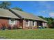 Charming brick home featuring a well-manicured lawn, blue shutters, and colorful potted plants at 2585 Old Jackson Rd, Locust Grove, GA 30248
