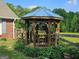 Wooden gazebo with metal roof in backyard, surrounded by lush greenery and fencing at 2585 Old Jackson Rd, Locust Grove, GA 30248
