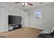 A bright bedroom with a ceiling fan, featuring a large screen TV on a stand at 4739 Lower Jersey Rd, Oxford, GA 30054