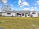 Inviting one-story brick home showcasing a sprawling front yard and covered porch with rocking chairs at 4739 Lower Jersey Rd, Oxford, GA 30054