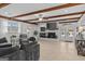 Spacious living room featuring exposed beams, a cozy fireplace, and modern lighting at 4739 Lower Jersey Rd, Oxford, GA 30054