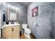 Stylish powder room featuring wood vanity, elegant lighting, and artistic wall texture at 3707 Lance Bluff Ln, Duluth, GA 30097