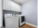 Laundry room featuring white washer and dryer with storage cabinets at 3707 Lance Bluff Ln, Duluth, GA 30097