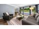 Cozy living room showcases neutral decor, large windows with backyard pool view and hardwood floors at 3707 Lance Bluff Ln, Duluth, GA 30097