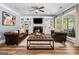 Cozy living room featuring hardwood floors, a fireplace, built-in shelving, and comfortable seating at 3707 Lance Bluff Ln, Duluth, GA 30097