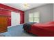 Bedroom with red accent wall, blue carpeting, ceiling fan, and built-in shelving at 604 Clearwater Ct, Mcdonough, GA 30252
