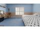 Bedroom with blue-and-beige walls, carpet flooring, and a shuttered window for ample natural light at 604 Clearwater Ct, Mcdonough, GA 30252