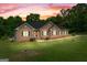 Stunning brick home featuring lush lawn and a beautiful sunset backdrop at 604 Clearwater Ct, Mcdonough, GA 30252