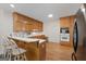 A bright kitchen features oak cabinets, modern built-in appliances, a breakfast bar, and hardwood floors at 604 Clearwater Ct, Mcdonough, GA 30252