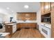 Spacious kitchen featuring wood cabinets, a breakfast bar, white appliances, and hardwood flooring at 604 Clearwater Ct, Mcdonough, GA 30252
