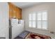 Functional laundry room features ample cabinets, modern washer and dryer, and natural light from the window at 604 Clearwater Ct, Mcdonough, GA 30252
