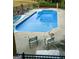 Inviting in-ground pool with a clear blue water, surrounded by a concrete patio and black metal fence at 604 Clearwater Ct, Mcdonough, GA 30252