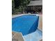 Clear blue in-ground pool with an adjacent house that has a deck with chairs and a table at 604 Clearwater Ct, Mcdonough, GA 30252
