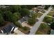 Aerial view of a neighborhood street and home with mature trees, a driveway, and a well-maintained yard at 70 Summer Walk Dr, Covington, GA 30016
