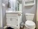 Bathroom featuring a vanity sink, mirror, storage cabinet, toilet, and gray walls at 70 Summer Walk Dr, Covington, GA 30016
