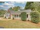 Cozy home with a covered front porch, green lawn, mature landscaping, and a welcoming entrance at 70 Summer Walk Dr, Covington, GA 30016