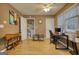 Tan office with a desk, chair, two windows, and a dog kennel at 70 Summer Walk Dr, Covington, GA 30016