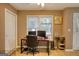 Tan office with a desk, chair, two windows, and a dog kennel at 70 Summer Walk Dr, Covington, GA 30016