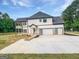 New construction home showcasing a modern garage with glass panel doors and second-story balcony at 1465 Leach Dr, Lawrenceville, GA 30045