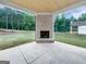 Spacious outdoor living area featuring a brick fireplace, concrete flooring, and a wooden ceiling at 1465 Leach Dr, Lawrenceville, GA 30045