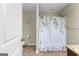 Clean bathroom featuring a toilet, shower with curtain, and neutral colored walls at 71 Pacific Ave, Sharpsburg, GA 30277