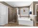Well-lit bathroom featuring tiled floors, shower, and soaking tub underneath a window at 71 Pacific Ave, Sharpsburg, GA 30277