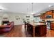 Kitchen with stainless appliances, kitchen island, stone countertops, hardwood floors, and a brick fireplace at 71 Pacific Ave, Sharpsburg, GA 30277