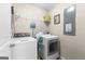Bright laundry room equipped with a washer, dryer, and ample storage shelving at 71 Pacific Ave, Sharpsburg, GA 30277