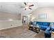 Inviting living room with neutral walls, plush carpet, ceiling fan, and comfortable blue sofa at 71 Pacific Ave, Sharpsburg, GA 30277