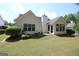 Manicured backyard featuring well-maintained lawn, mature trees, and vinyl siding at 300 Cloverwood Dr, Fayetteville, GA 30215