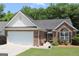 Charming single-story brick home with an attached garage, well-manicured lawn, and mature landscaping at 300 Cloverwood Dr, Fayetteville, GA 30215