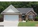 A well-maintained brick home featuring a two-car garage and front lawn at 300 Cloverwood Dr, Fayetteville, GA 30215