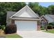 Attached two car garage with brick facade and well maintained landscaping at 300 Cloverwood Dr, Fayetteville, GA 30215