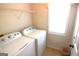 Functional laundry room with washer, dryer, storage shelves and natural light at 300 Cloverwood Dr, Fayetteville, GA 30215
