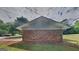 Brick detached garage with a gable roof and mature trees, complemented by a well-maintained yard at 1102 Tony Valley Se Dr, Conyers, GA 30013