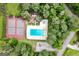 Aerial view showcasing community pool and tennis courts amidst lush, mature trees at 145 Oxford Ln, Fayetteville, GA 30215