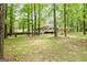 Expansive backyard with lush greenery, mature trees, and a charming play area at 145 Oxford Ln, Fayetteville, GA 30215