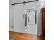 Modern bathroom entry with a sliding barn door and neutral tiling in the shower at 145 Oxford Ln, Fayetteville, GA 30215