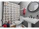 Elegant bathroom showcasing a pedestal sink, an oval mirror, and a decorative bird-themed shower curtain at 145 Oxford Ln, Fayetteville, GA 30215