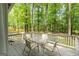 Relaxing outdoor deck featuring a glass table and comfortable seating amidst lush greenery at 145 Oxford Ln, Fayetteville, GA 30215