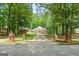 Classic brick home with well-kept lawn, surrounded by lush trees, with a long driveway leading up to the house at 145 Oxford Ln, Fayetteville, GA 30215