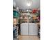Organized laundry room with washer, dryer, and ample shelving at 145 Oxford Ln, Fayetteville, GA 30215