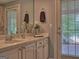 Bright bathroom with double vanity, fresh flowers, and natural light at 205 Somerset Ct, Mcdonough, GA 30253