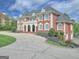 Elegant brick home with stately curb appeal, featuring a circular driveway and meticulously maintained landscaping at 205 Somerset Ct, Mcdonough, GA 30253
