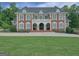 Stately brick home with a manicured lawn and grand entrance featuring a balcony and columns at 205 Somerset Ct, Mcdonough, GA 30253
