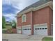 Three-car garage showcasing the side of the brick home and driveway at 205 Somerset Ct, Mcdonough, GA 30253