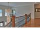 Second floor hallway includes a decorative chandelier, staircase, and hardwood floors at 205 Somerset Ct, Mcdonough, GA 30253