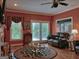 Cozy living room with hardwood floors, fireplace, and ample natural light from large windows at 205 Somerset Ct, Mcdonough, GA 30253