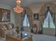 Elegant living room with a crystal chandelier, sophisticated drapery, and plush seating, perfect for formal gatherings at 205 Somerset Ct, Mcdonough, GA 30253